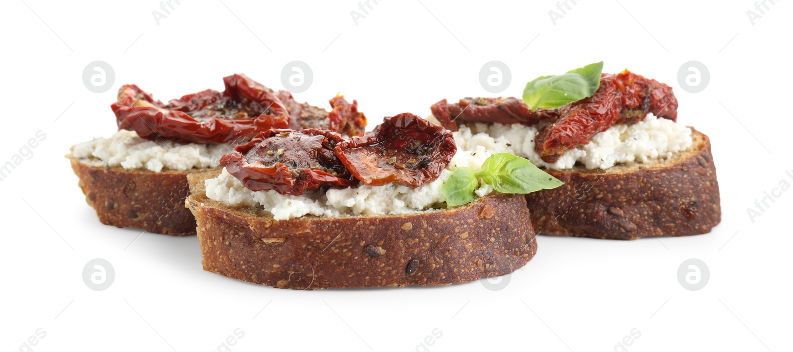 Photo of Delicious ricotta bruschettas with sun dried tomatoes and basil isolated on white