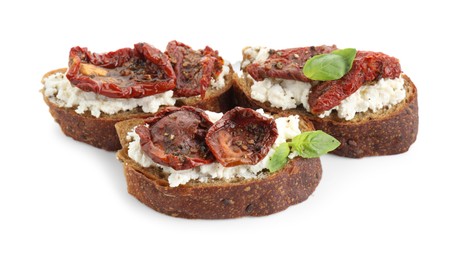 Photo of Delicious ricotta bruschettas with sun dried tomatoes and basil isolated on white