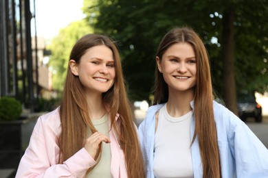 Photo of Portrait of two beautiful twin sisters outdoors