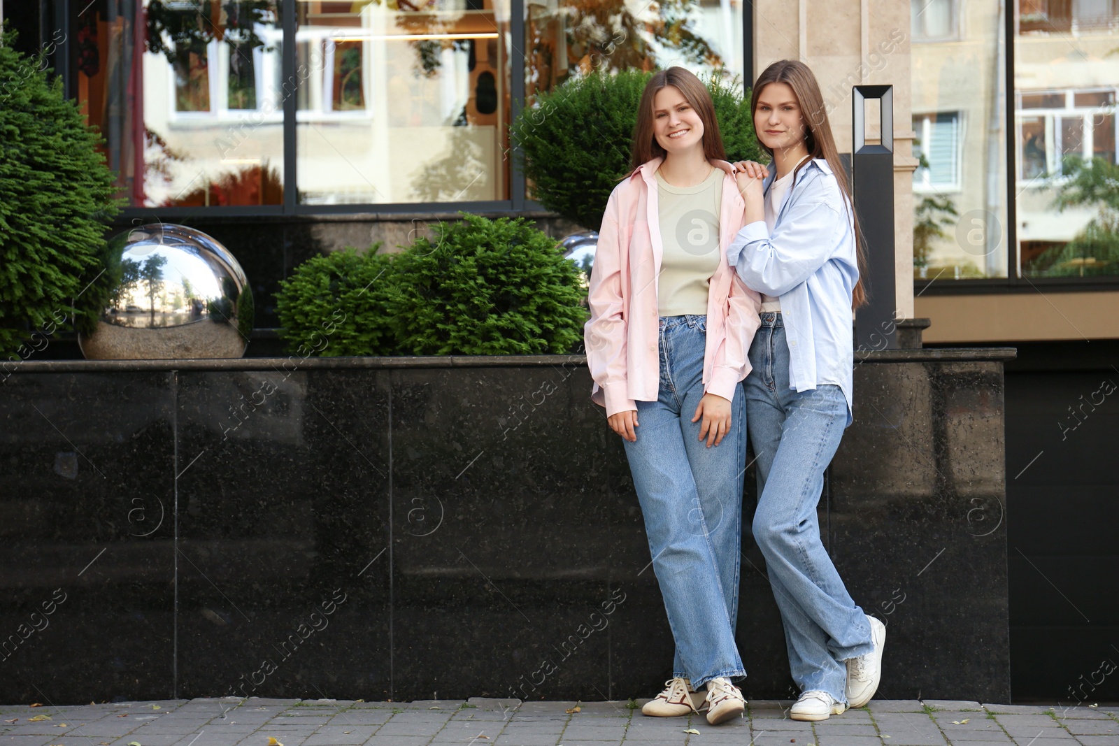 Photo of Portrait of two beautiful twin sisters outdoors