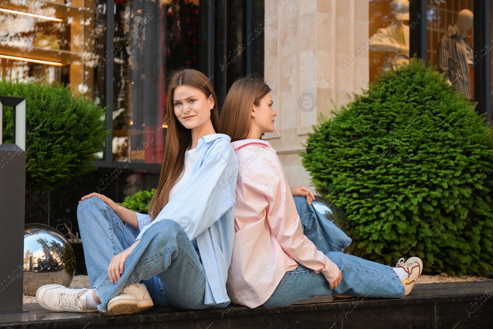 Photo of Portrait of two beautiful twin sisters outdoors