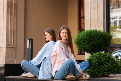 Photo of Portrait of two beautiful twin sisters outdoors