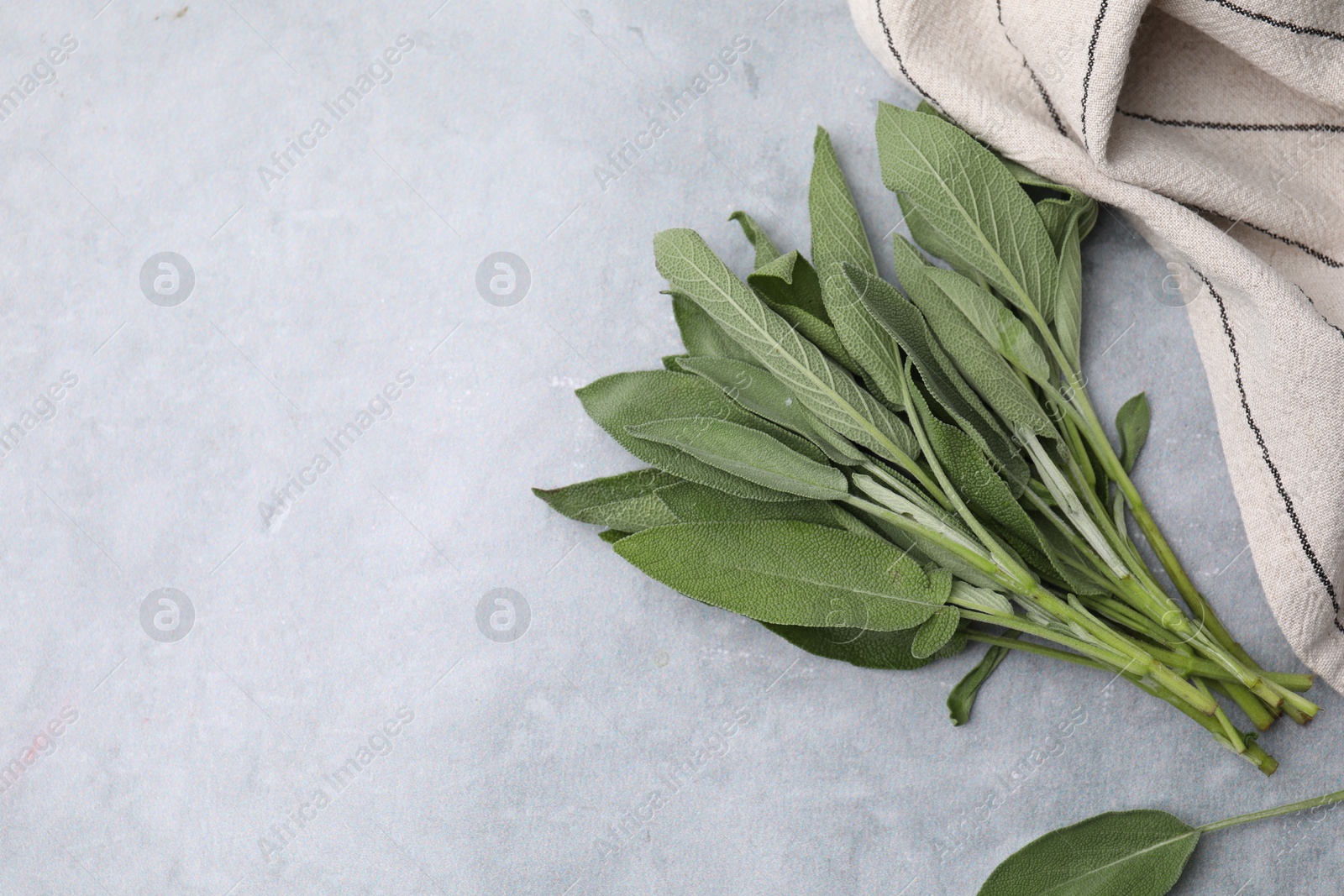 Photo of Fresh sage leaves on grey table, top view. Space for text