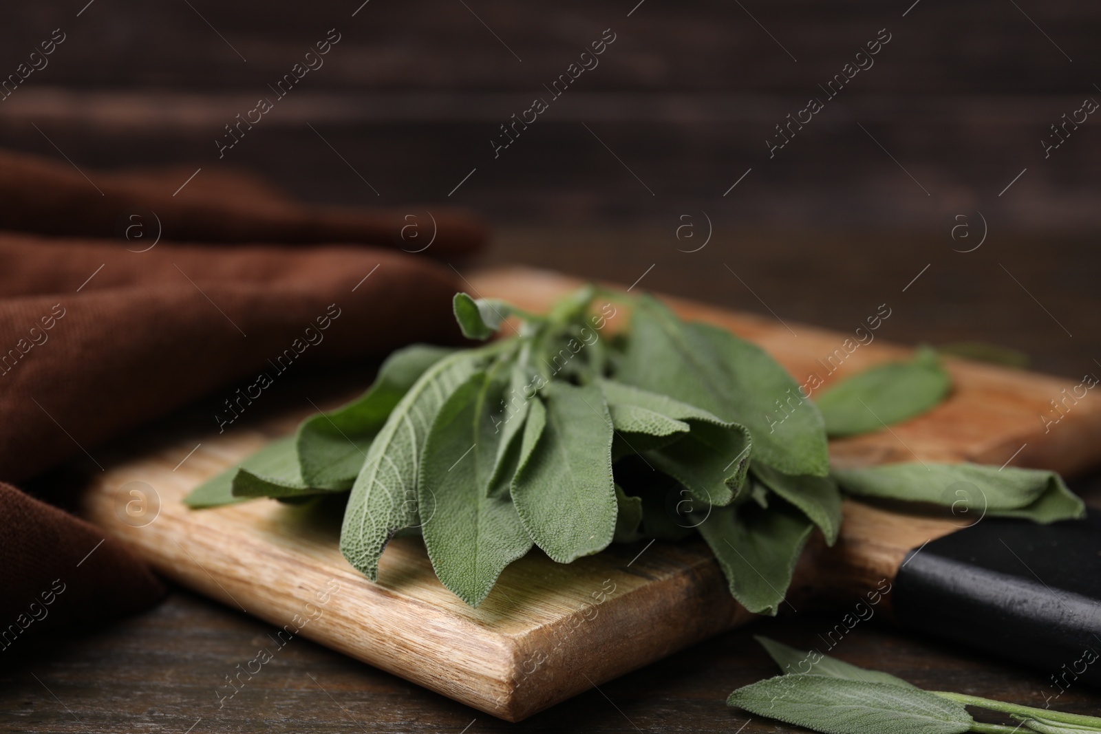 Photo of Fresh sage leaves on wooden table, closeup