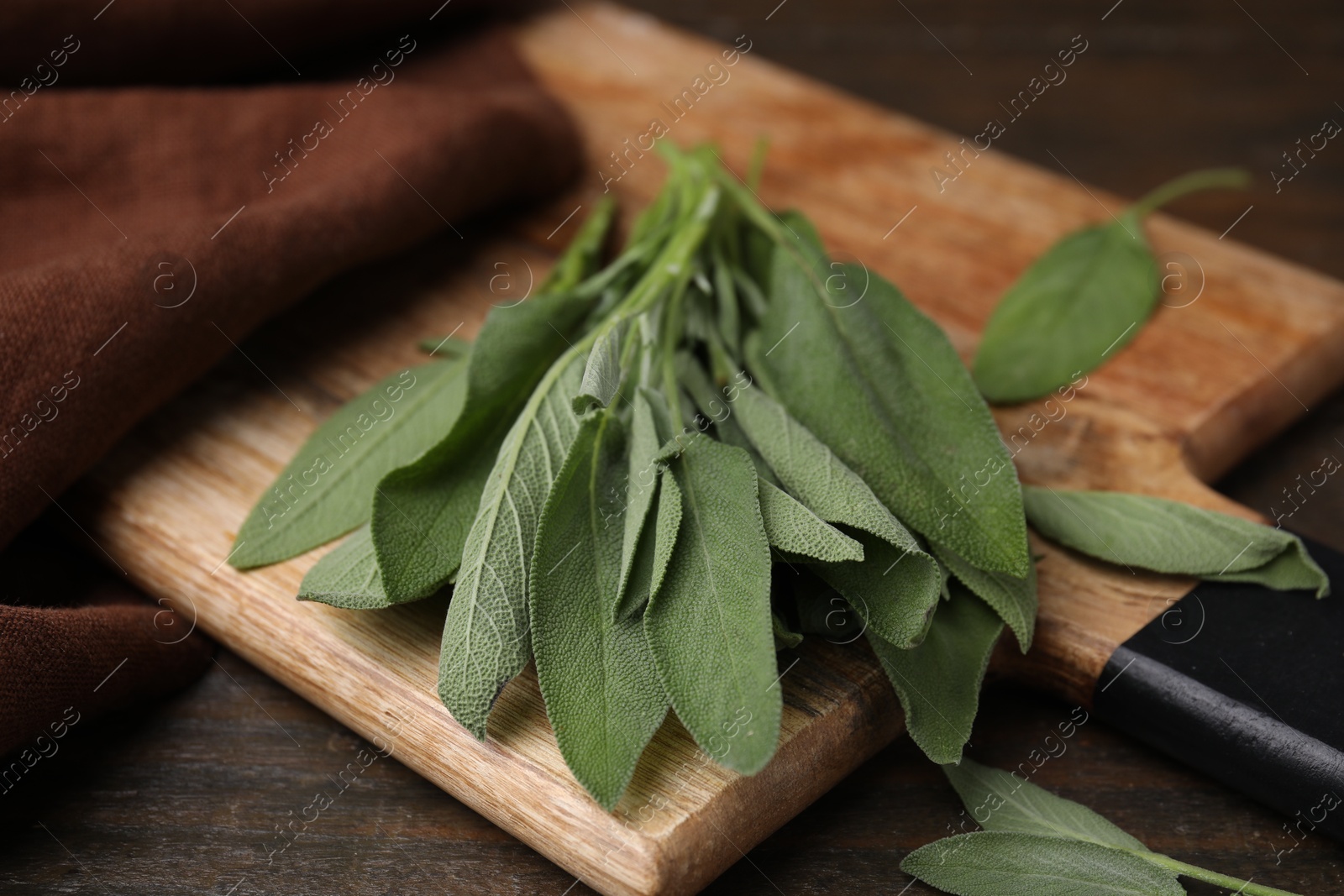 Photo of Fresh sage leaves on wooden table, closeup