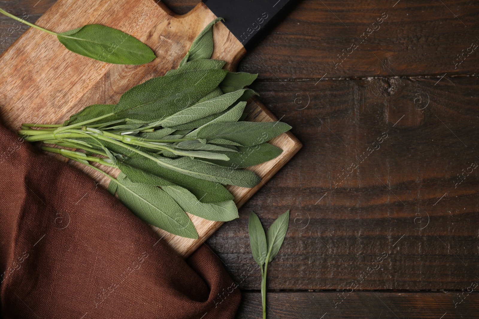 Photo of Fresh sage leaves on wooden table, top view. Space for text