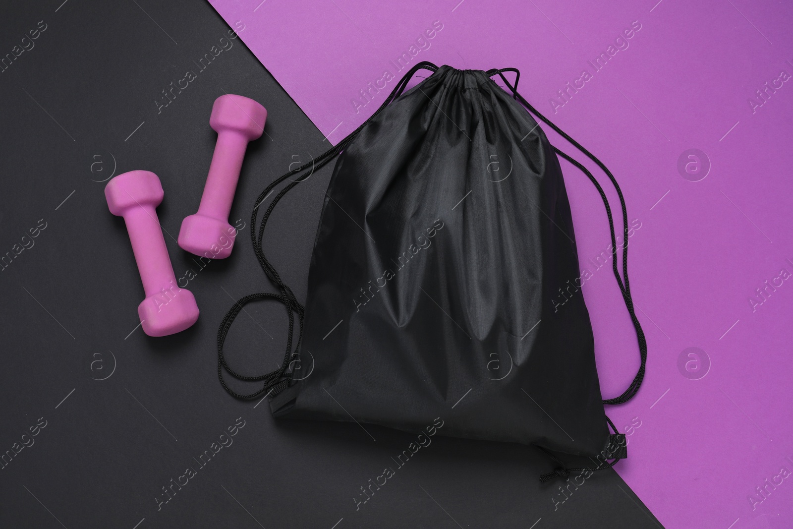 Photo of Black drawstring bag and dumbbells on color background, flat lay