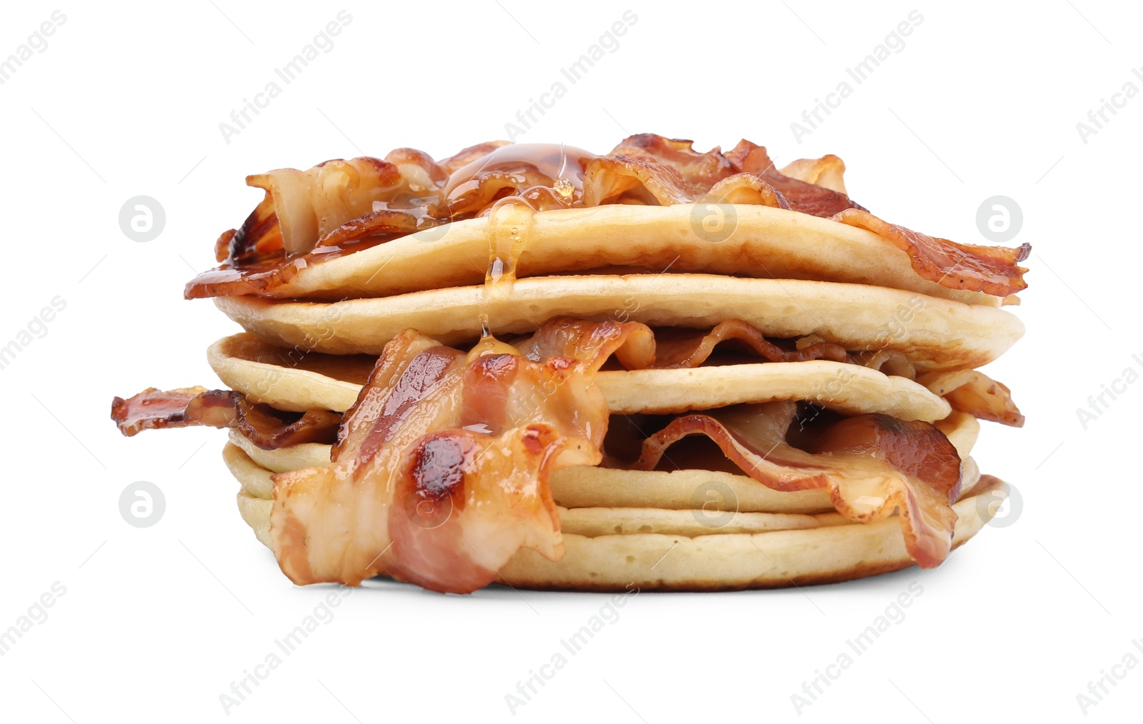 Photo of Pouring maple syrup onto delicious pancakes with fried bacon isolated on white