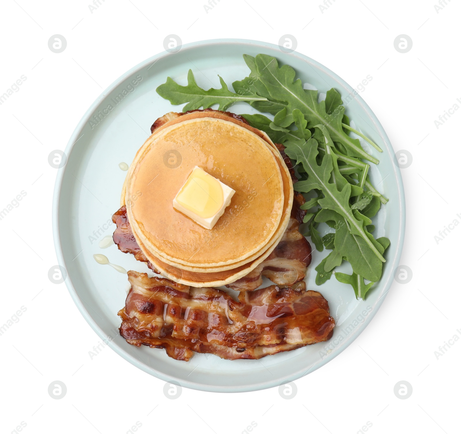 Photo of Tasty pancakes with butter, fried bacon and fresh arugula isolated on white, top view