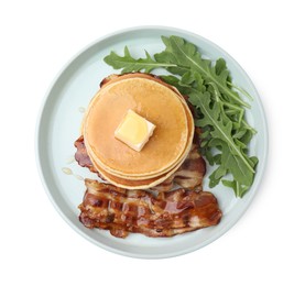 Tasty pancakes with butter, fried bacon and fresh arugula isolated on white, top view