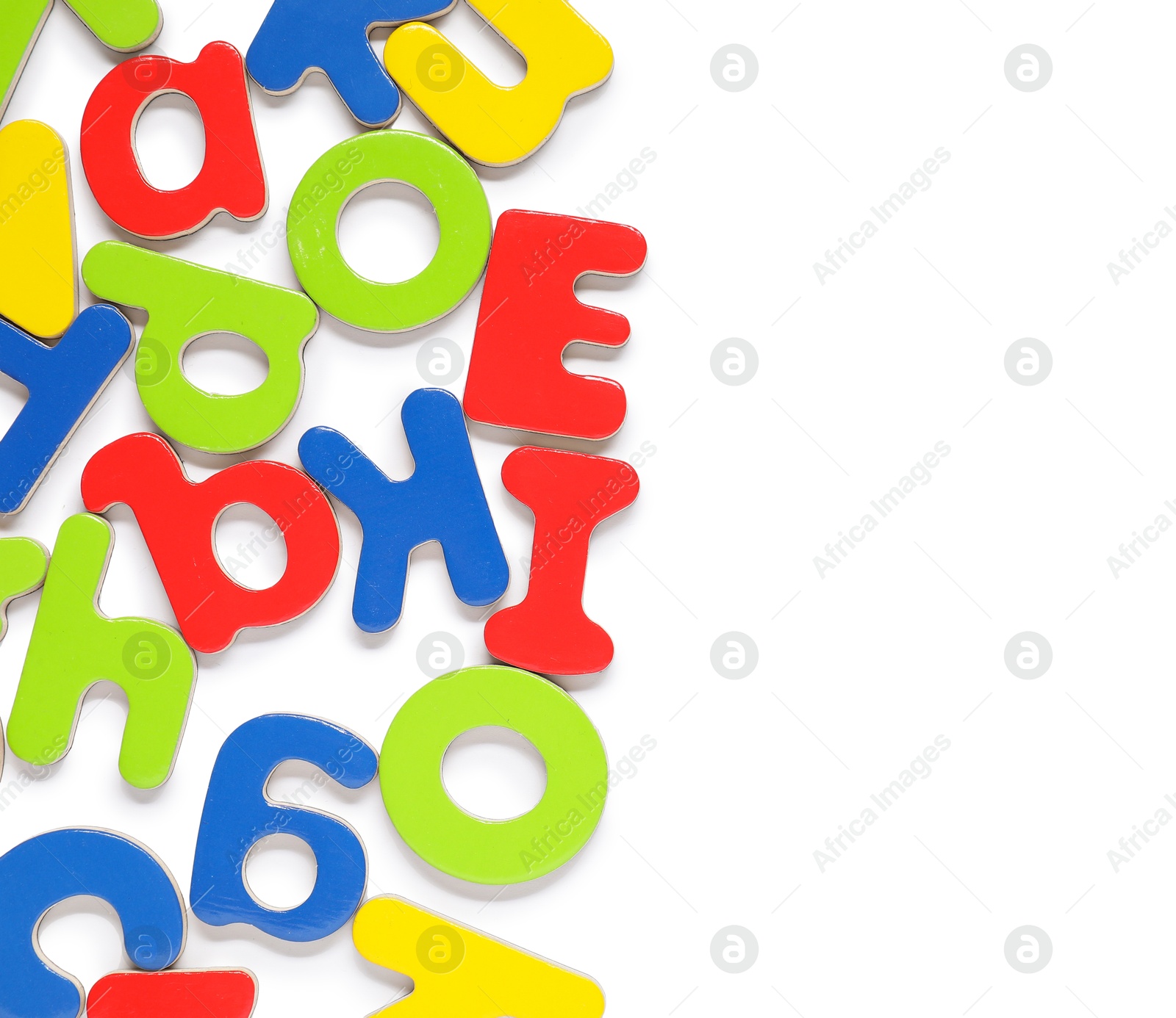 Photo of Alphabet. Many colorful magnetic letters isolated on white, top view