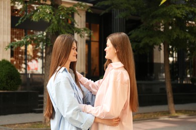 Photo of Two beautiful twin sisters spending time together outdoors