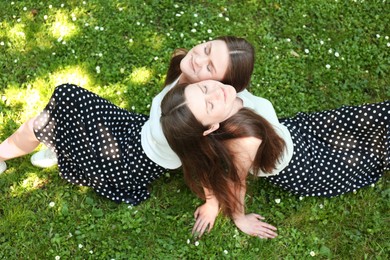 Photo of Two beautiful twin sisters spending time together in park, above view