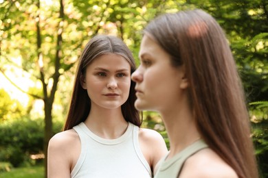 Two beautiful twin sisters in park, selective focus