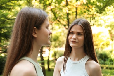 Photo of Two beautiful twin sisters in park, selective focus