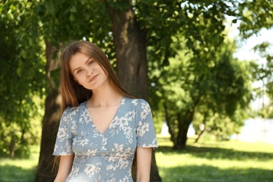 Portrait of beautiful woman in summer park. Space for text