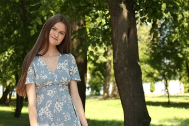 Portrait of beautiful woman in summer park. Space for text