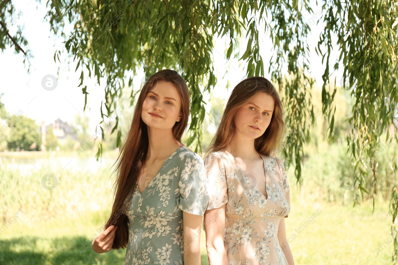 Photo of Portrait of two beautiful twin sisters in park