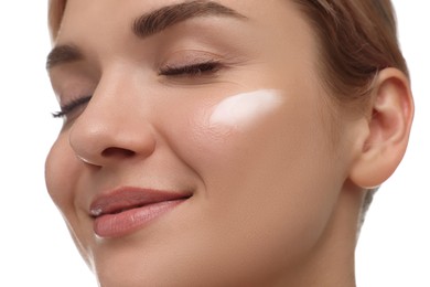 Beautiful woman with cream on her face against white background, closeup