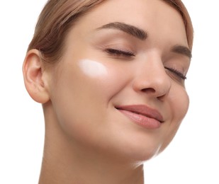 Beautiful woman with cream on her face against white background, closeup