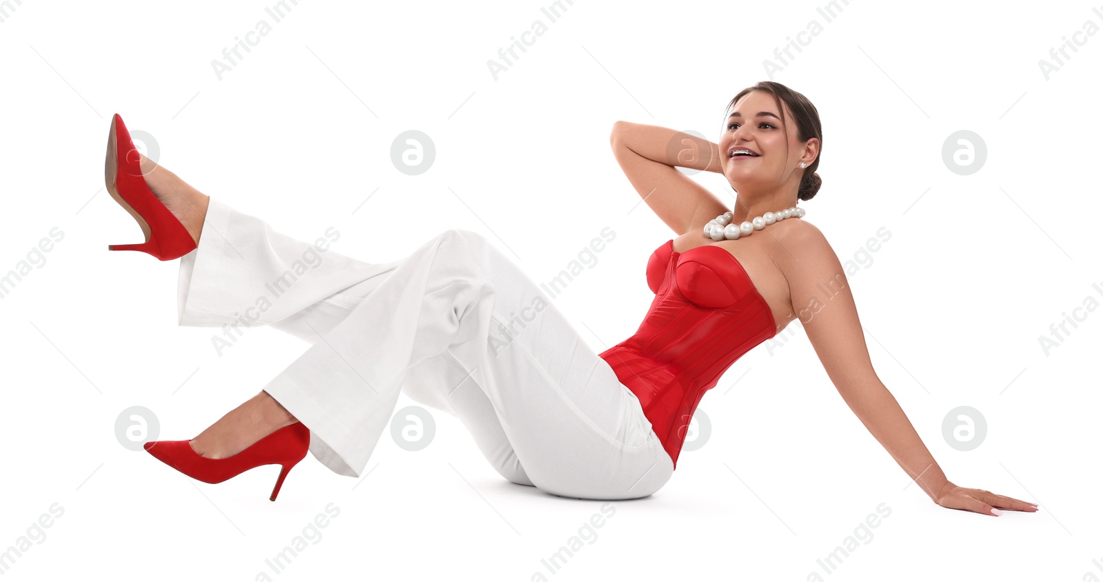 Photo of Smiling woman in red corset posing on white background