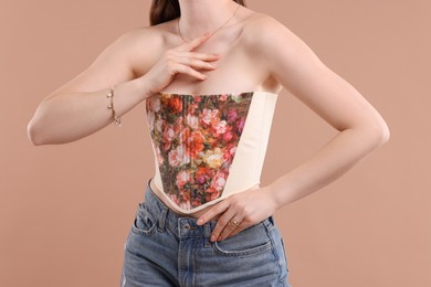 Woman in stylish corset on beige background, closeup