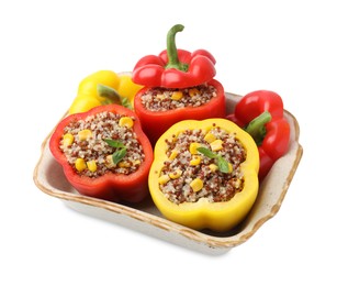 Photo of Quinoa stuffed bell peppers and basil in baking dish isolated on white