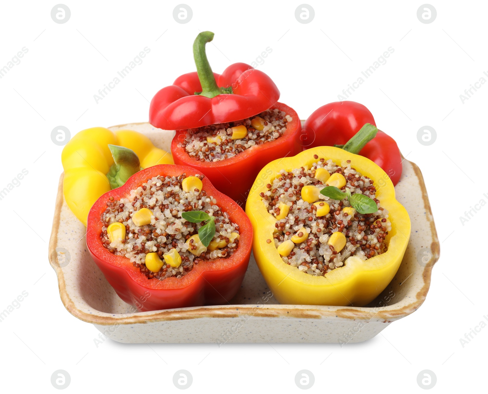 Photo of Quinoa stuffed bell peppers and basil in baking dish isolated on white