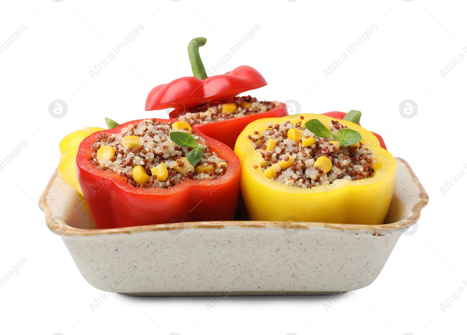 Photo of Quinoa stuffed bell peppers and basil in baking dish isolated on white