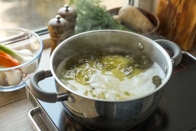 Boiling potatoes in pot on stove in kitchen