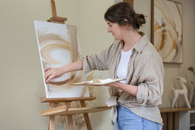 Photo of Woman with palette drawing picture in studio