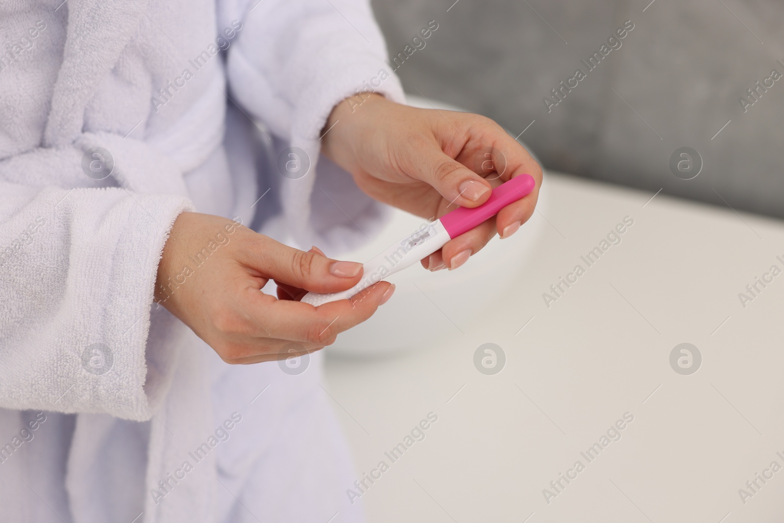 Photo of Woman holding pregnancy test in bathroom, closeup. Space for text