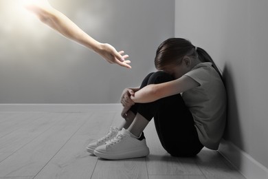 Man offering hand to sad child indoors. Trust, support, help