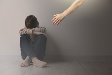 Image of Man offering hand to sad child indoors. Trust, support, help