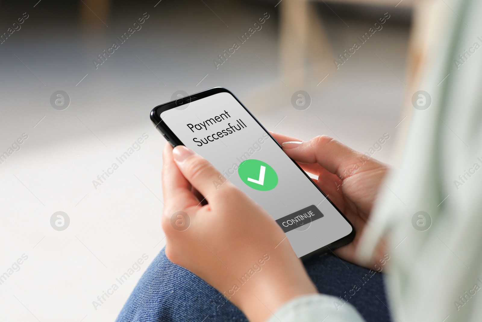 Image of Woman using online payment application on mobile phone at home, closeup