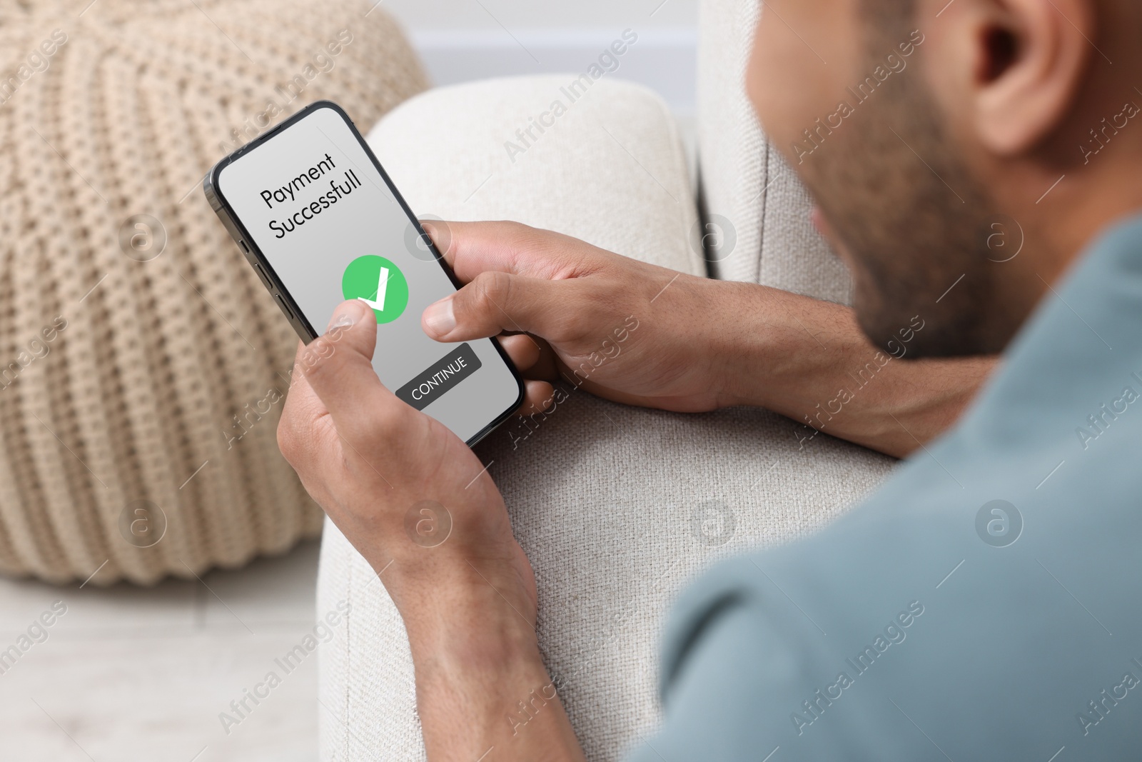 Image of Man using online payment application on mobile phone at home, closeup