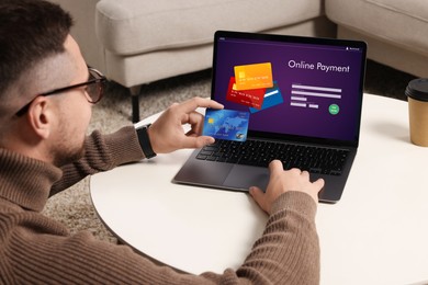 Image of Man using online payment application on laptop at home
