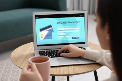 Image of Woman using online payment application on laptop at home, closeup