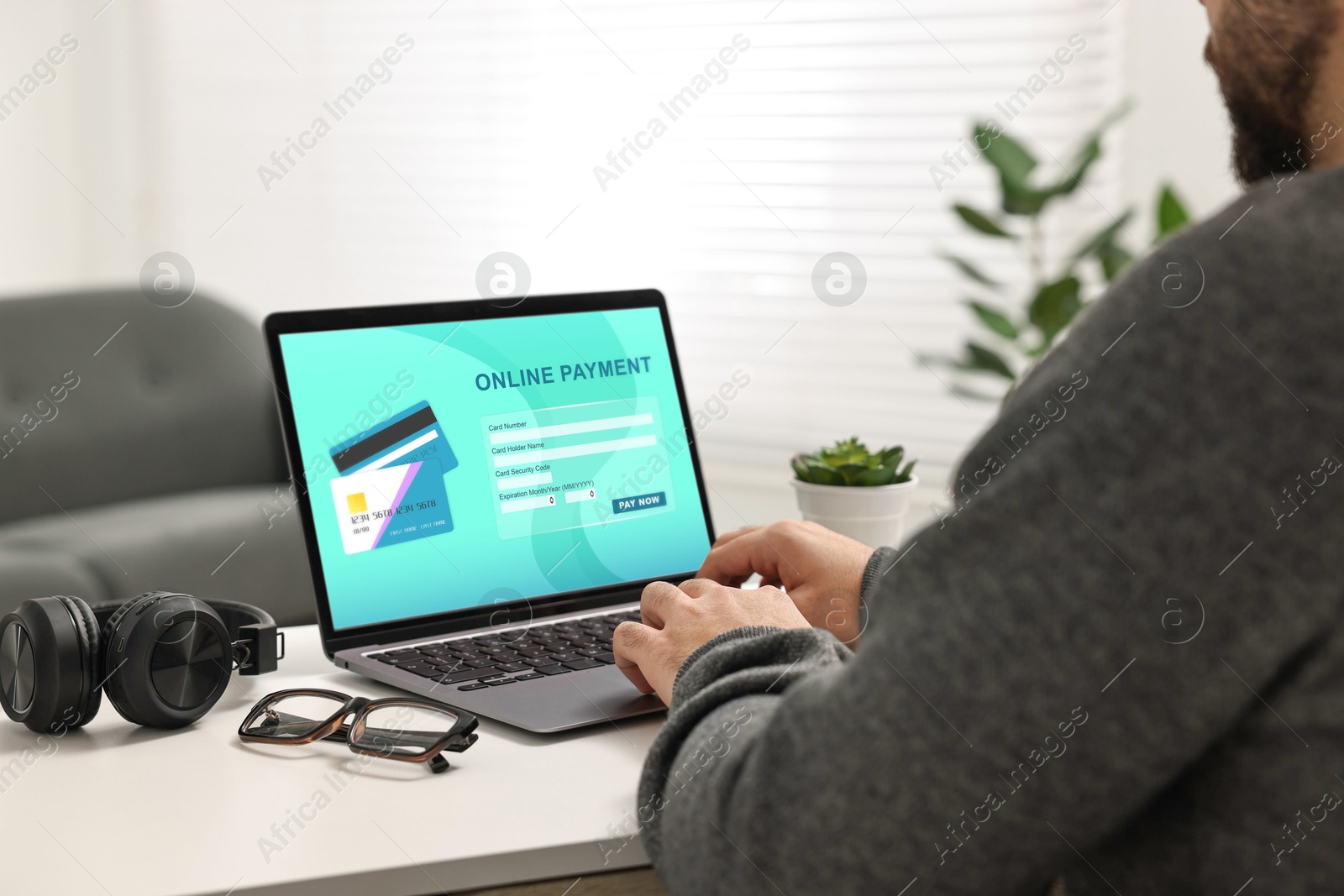 Image of Man using online payment application on laptop at home, closeup