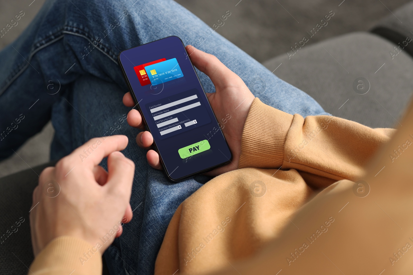 Image of Man using online payment application on mobile phone at home, closeup