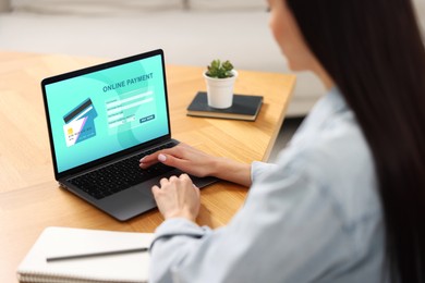 Image of Woman using online payment application on laptop at table, closeup