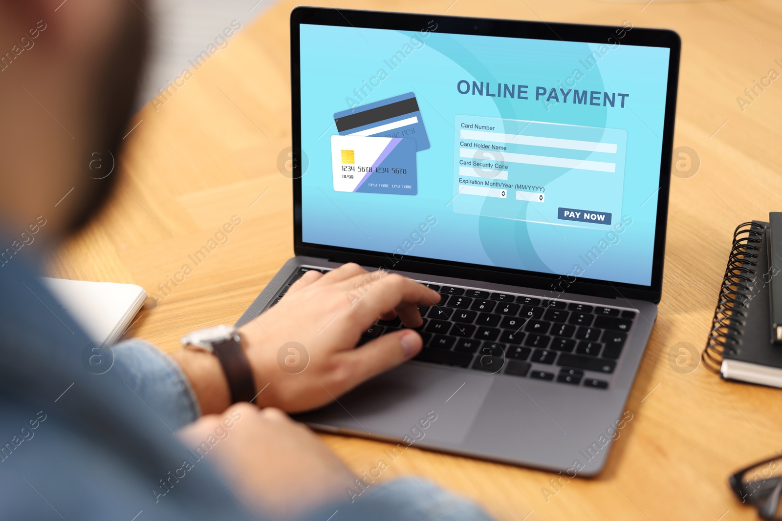 Image of Man using online payment application on laptop at table, closeup