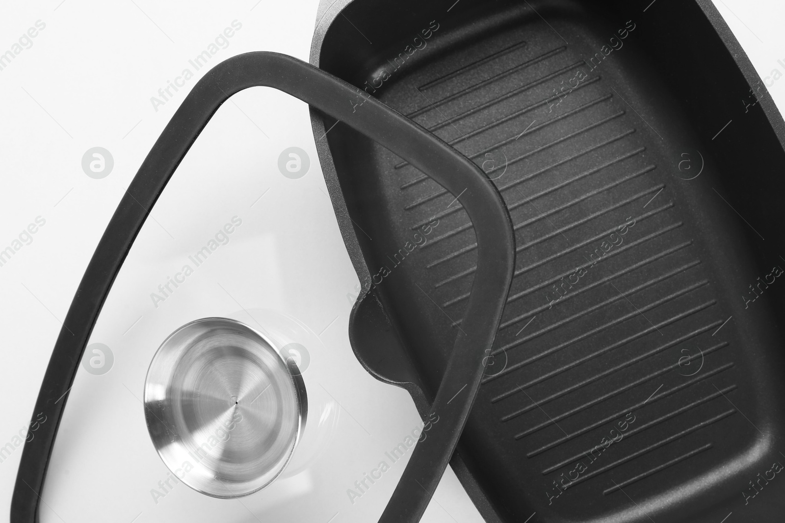 Photo of Black pot and glass lid on white background, top view