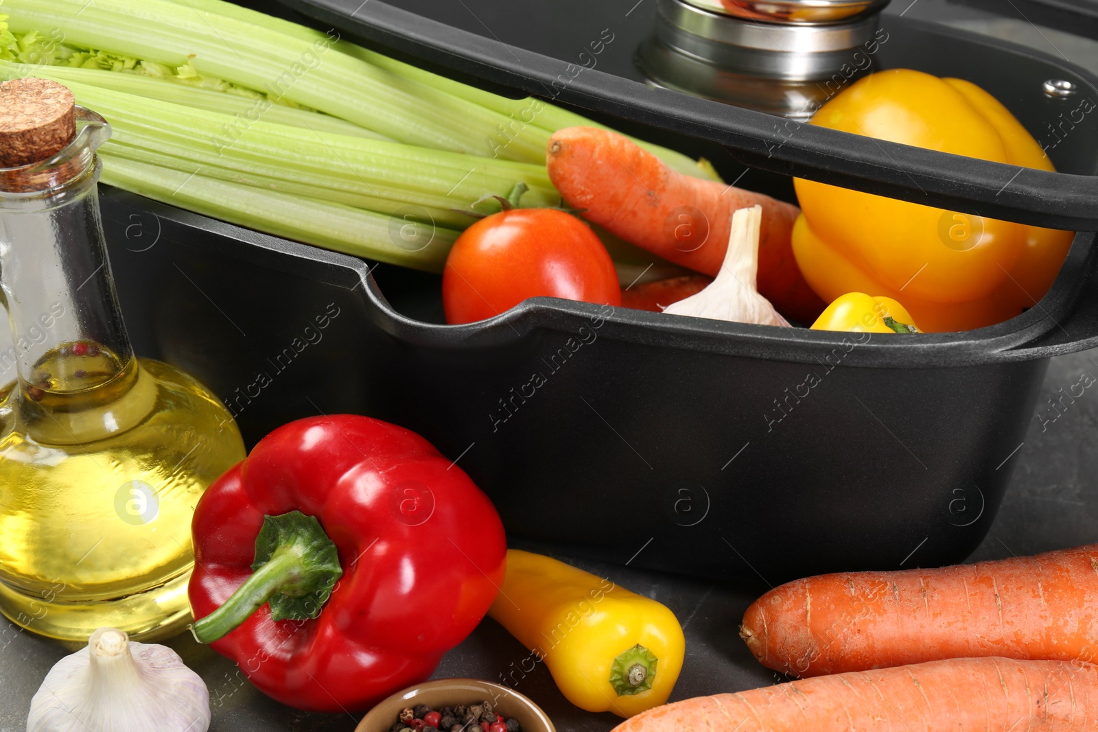 Photo of Black pot and fresh products on grey table