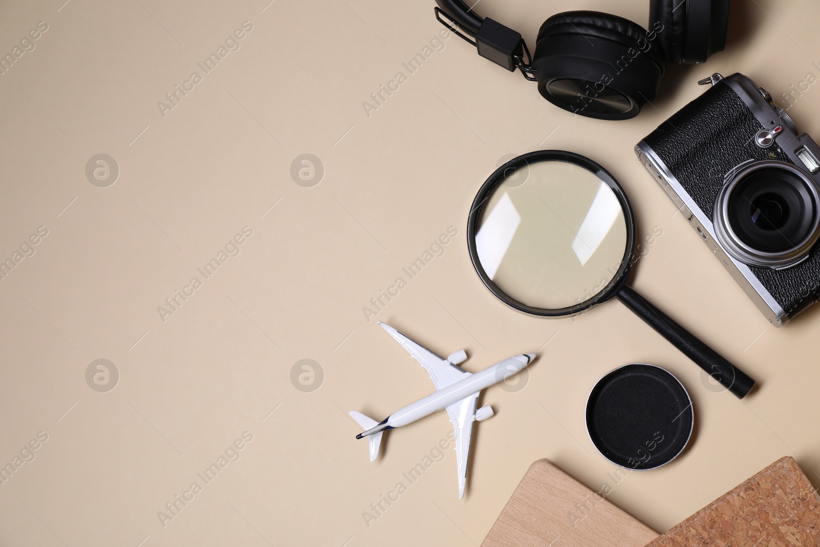 Photo of Travel blogger. Flat lay composition with vintage camera and magnifying glass on beige background, space for text