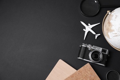 Travel blogger. Flat lay composition with vintage camera on black background, space for text