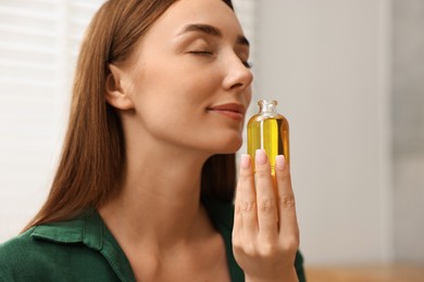 Aromatherapy. Beautiful woman with bottle of essential indoors