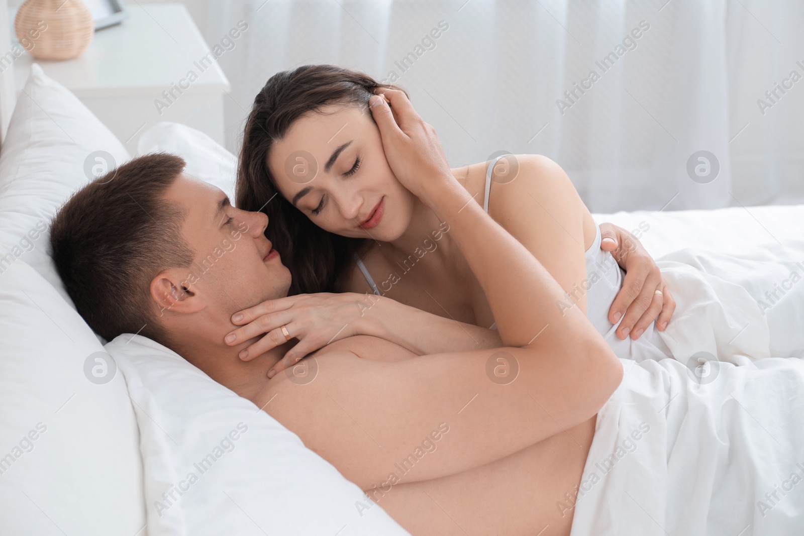 Photo of Lovely couple hugging in bed at home