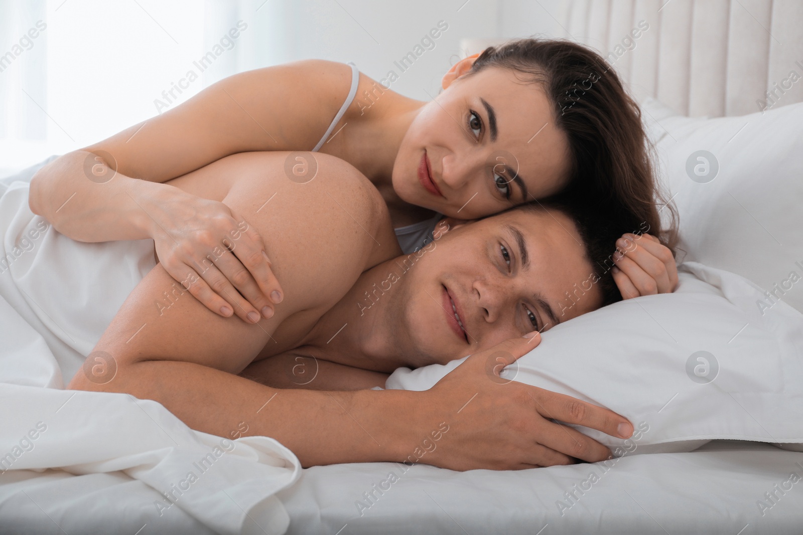 Photo of Lovely couple lying in bed at home