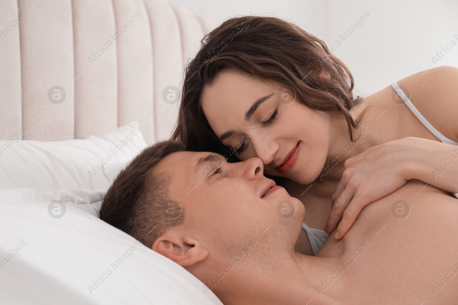 Photo of Lovely couple lying on bed at home